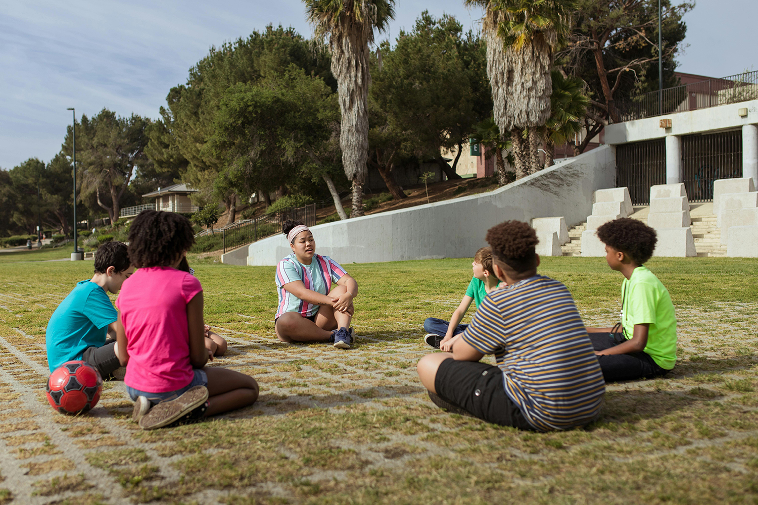 children sitting in a circle on grass