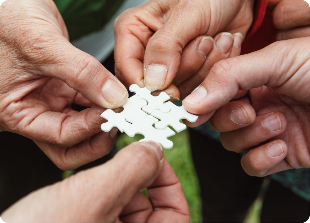 hands fitting puzzle pieces together